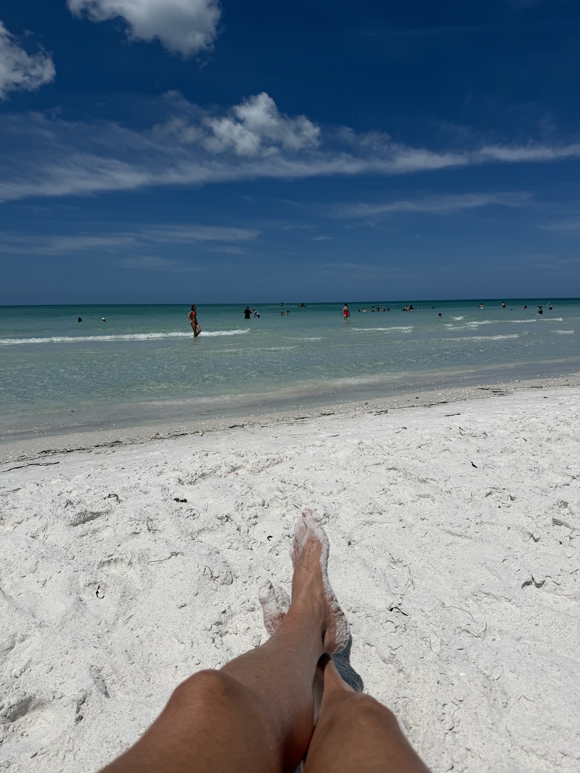Sandy feet overlooking the white sand and turquoise water at Lido Beach